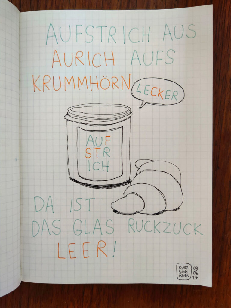 Eine schnelle Linienzeichnung in kariertes Buch eines Aufstrichglases und eines Croissants. 
Drumherum steht "Aufstrich aus Aurich aufs Krummhörn – da ist das Glas ruckzuck Leer!"
Auf dem Glas steht das Wort Aufstrich, das f, s, t sind farblich anders dargestellt, so dass das Wort Aurich hervorgehoben wird. Neben dem Glas steht eine Sprechblase mit dem Wort lecker, das c und k sind farblich anders dargestellt, so dass das Wort Leer hervorgehoben wird. 
Die drei Worte sind Orte in Ostfriesland. 