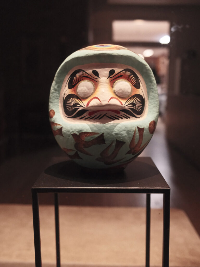 Eine japanische Daruma-Figur in einem Schaufenster.